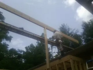 Carpenter setting a ridge beam over a new addition frame — Ice Dam Removal by Roofing Brothers in Mongo