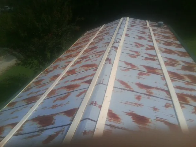 Rusted metal roof panels with new wood purlins before replacement — Storm Damage Roof Repair in Mongo by Roofing Brothers