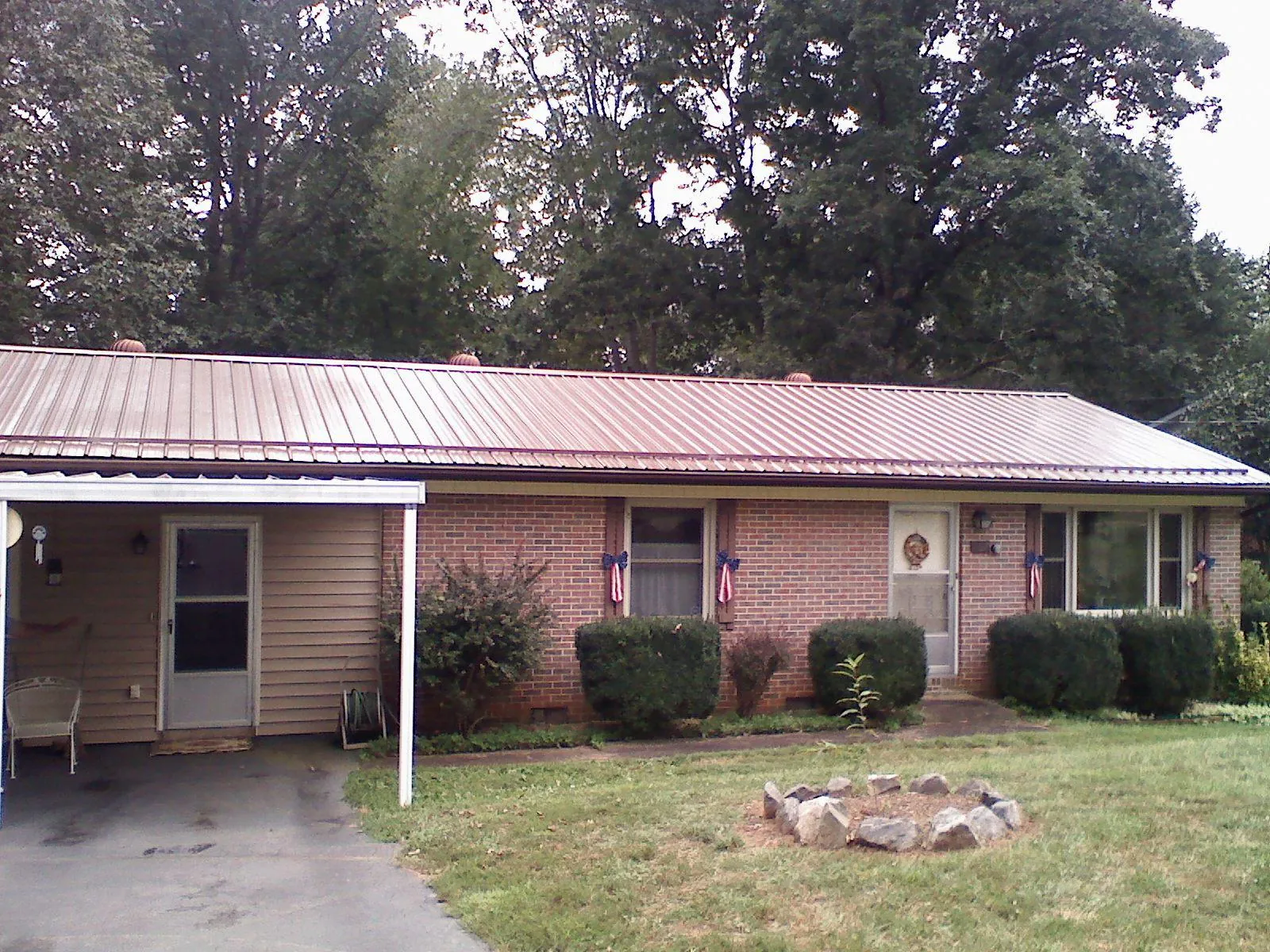 Bronze metal roof and carport on a brick ranch home — Roof Repair work by our crew in Mongo